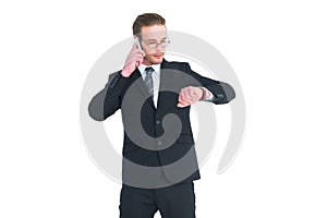 Serious businessman phoning while checking time