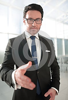 Serious businessman reaching out for a handshake