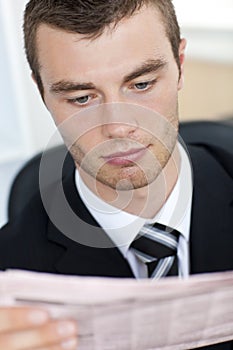 Serious businessman reading the newspaper