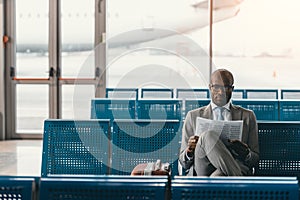 serious businessman reading newspaper waiting for flight