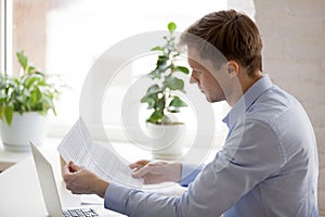 Serious businessman reading paper document, notification, busine