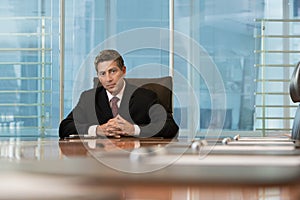 Serious Businessman Sitting At Conference Table