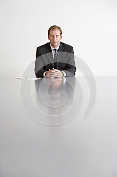 Serious Businessman Sitting At Conference Table