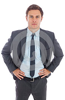 Serious businessman standing with hands on hips