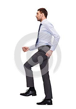 Serious businessman stepping on imaginary step