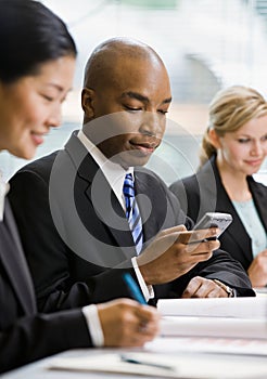 Serious businessman text messaging on cell phone