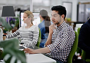 Serious, businessman and thinking at desk with computer for research on company project in group workplace. Male person