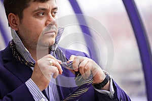 Serious businessman tying his tie