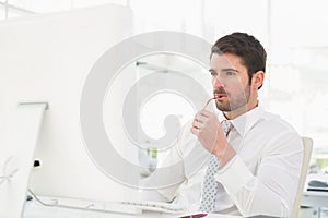 Serious businessman using computer monitor