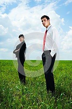 Serious businesspeople standing on meadow