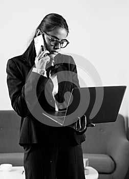 Serious businesswoman answering telephone at office desk. Young business woman freelancer or ceo employee working in