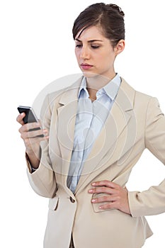 Serious businesswoman posing with phone on right hand