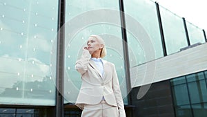 Serious businesswoman with smartphone outdoors