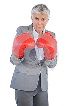 Serious businesswoman standing with her boxing gloves