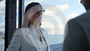 Serious businesswoman talking manager at office panorama window close up.