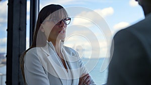 Serious businesswoman talking manager at office panorama window close up.