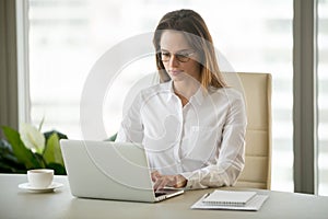 Serious businesswoman using computer business software sitting a