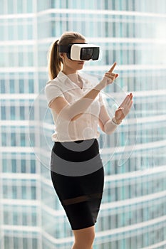 Serious businesswoman in VR headset trying virtual reality 3d to