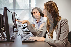 Serious businesswomen looking at computer screen together