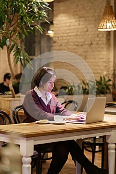 Serious busy afro female writer or journalist work in cafe use laptop and wifi internet connection
