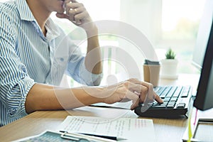 Serious busy hipster young web software developer programmer is coding or programming on a desktop computer information in modern