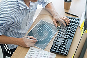 Serious busy hipster young web software developer programmer is coding or programming on a desktop computer information in modern