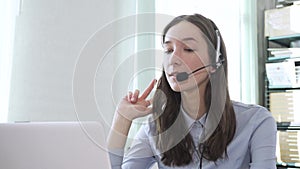 Serious call center operator in wireless headset talking with customer, close up