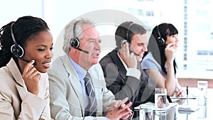 Serious call centre agents talking with headsets