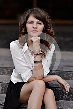 Serious,calm,hard-working,assured in school uniform sit on modern stairs