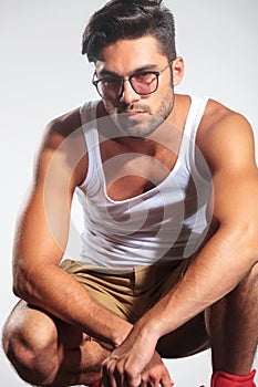 Serious casual man in undershirt standing crouched