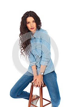Serious casual young woman posing while sitting