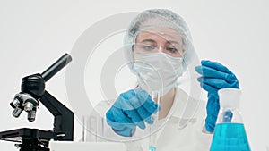 Serious caucasian female scientist pipetting an assay samples