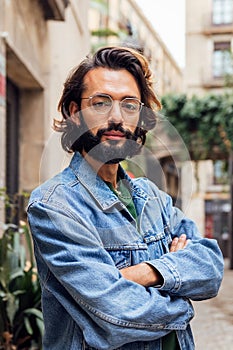 serious caucasian man with arms crossed at street