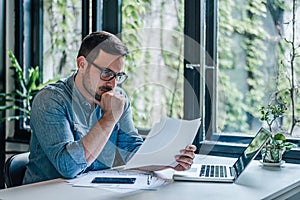 Serious caucasian man, checking the company files