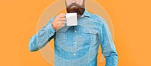 Serious caucasian man crop view holding tea mug yellow background
