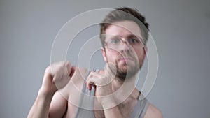 Serious caucasian man in huge glasses making strange dancing movements.