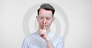 Serious Caucasian Man Hush Gesture on White Background