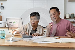 Serious caucasian old elderly senior couple grandparents family counting funds on calculator, doing paperwork, savings, paying