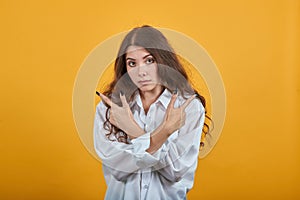 Serious woman keeping hands crossed, pointing fingers aside, looking at camera