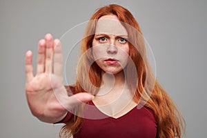 Serious Caucasian woman making stop gesture