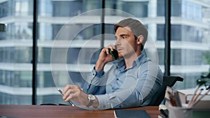 Serious ceo answering phone call at office closeup. Man talking smartphone