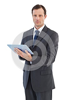 Serious charismatic businessman holding a tablet computer