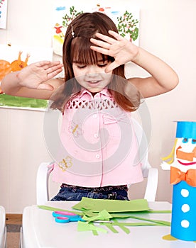 Serious child cutting paper.