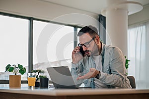 Serious company executive, talking to his employee over the phone