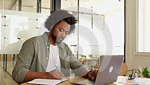 Serious concentrated young african-american businessman, ceo, manager working on laptop