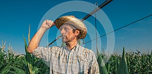 Serious concerned farmer in cornfield with irrigation system
