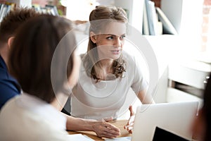 Serious confident businesswoman at meeting with subordinates