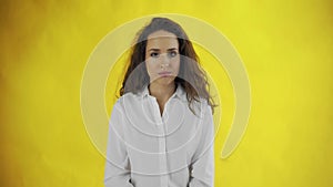 Serious confident long-haired woman saying no shaking head in denial over yellow background