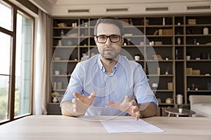 Serious confident millennial business professional in glasses looking at camera