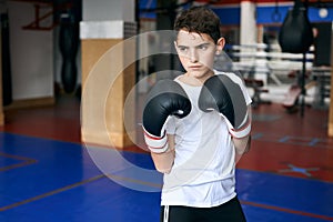 Serious confident sweaty tired boy standing in boxing position